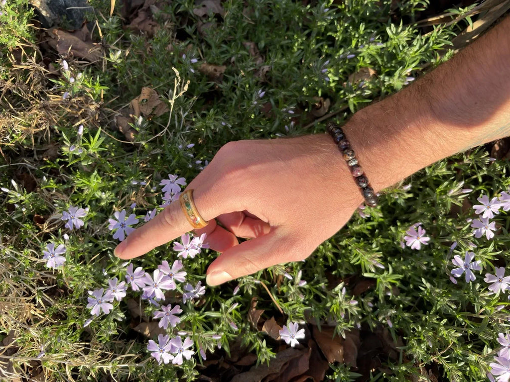 Floral Bloom wedding band worn outdoors among flowers