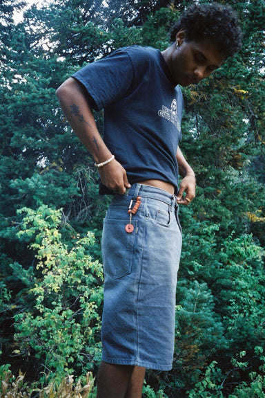 Rose Rebirth Carabiner Keychain clipped to a pocket in the forest